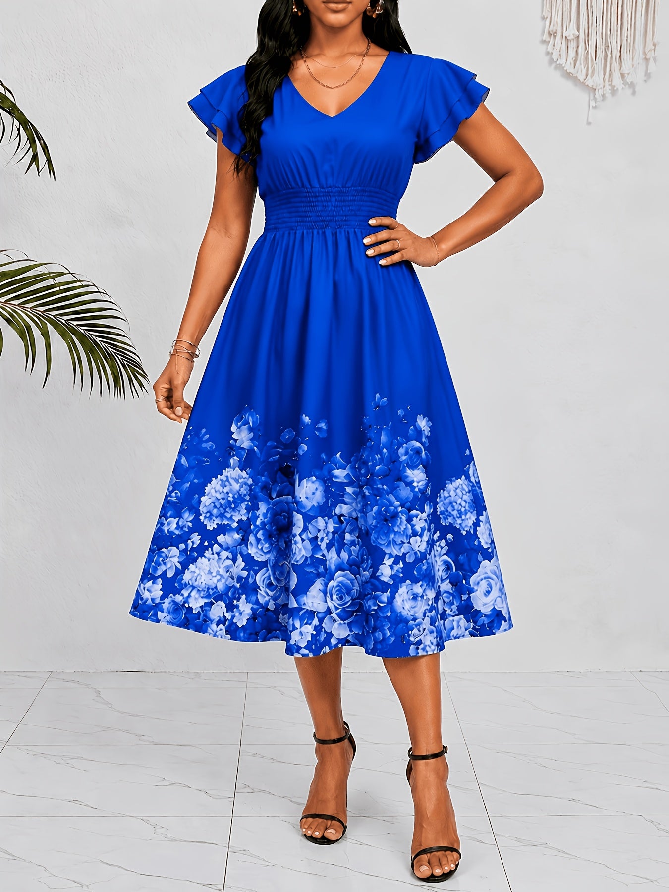 Mediterranean Style Royal Blue Floral Printed Dress with Flutter Sleeves, V-Neck, Cinched Waist, And a Flowing Skirt Perfect for Vacations